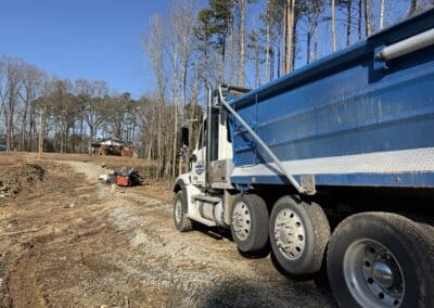 A truck rests on a hillside, with a backdrop of trees